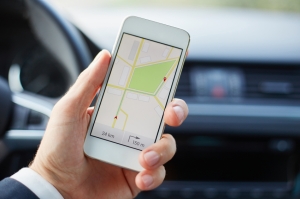Man using maps app on mobile phone in car